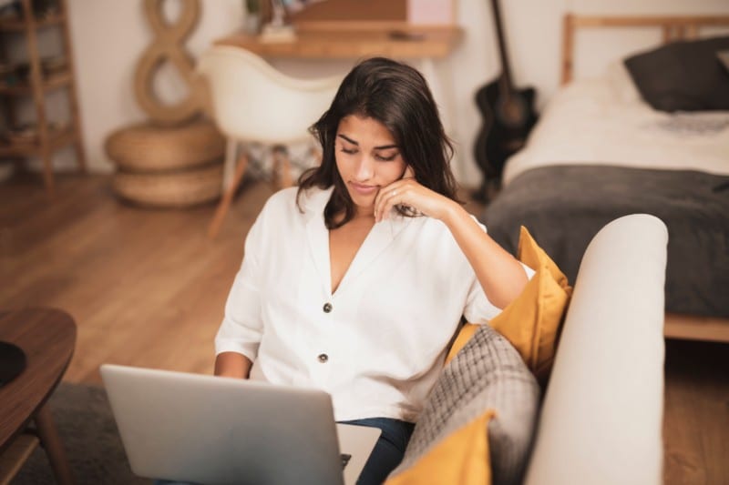 Woman sitting on couch and working from home